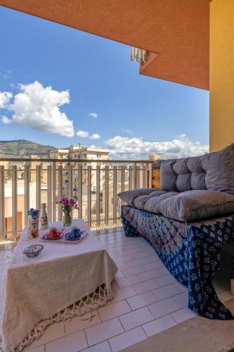 a living room with a couch and a table on a balcony at Apartment Yoga Frank in Trapani