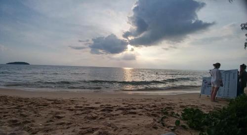 a man standing on the beach looking at the ocean at Sea inn guest house in Sihanoukville