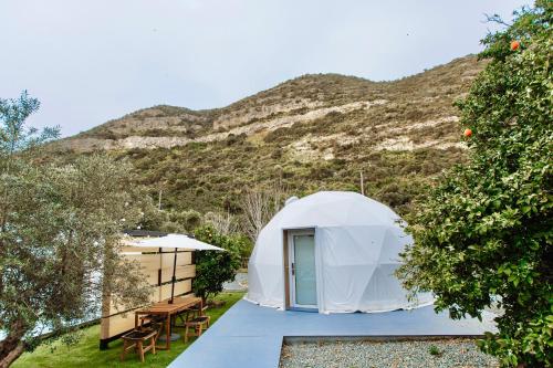 a white dome tent in front of a mountain at Geometry Park in Ayios Theodhoros