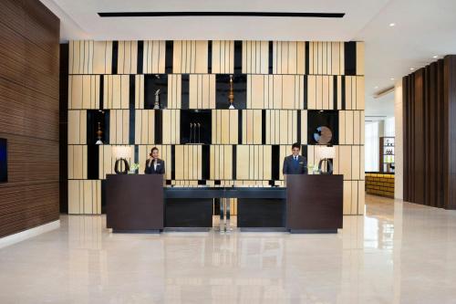 a lobby with three people in a large wall at Fairfield by Marriott Bengaluru Outer Ring Road in Bengaluru