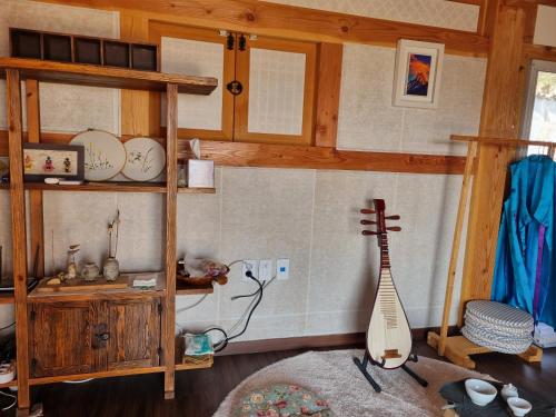 a room with a wooden shelf and a guitar at Seondosan Hanok Stay in Gyeongju