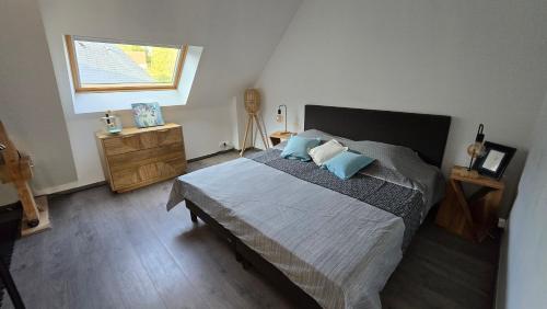 a bedroom with a bed with blue pillows and a window at Villa Bastilaure in Saint Pavace