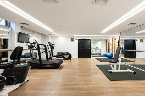 a gym with treadmills and exercise equipment in a room at Trumpeldor 1 - Luxury Beach Apartments Hotel - By Vacay in Tel Aviv
