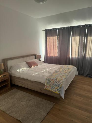 a bedroom with a bed and a window with curtains at Bavaria Rooms in Iaşi