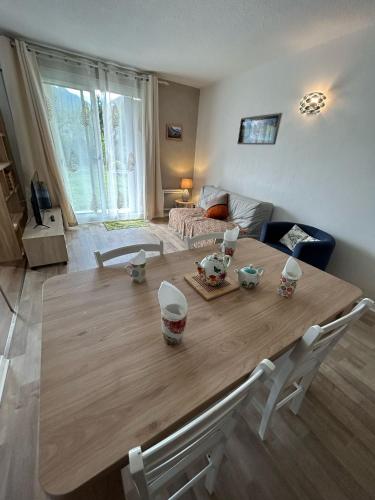 - un salon avec une grande table en bois et un canapé dans l'établissement Au coeur des montagnes, à Argelès-Gazost