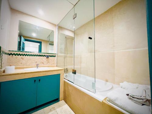 une salle de bain avec une baignoire, un lavabo et une douche dans l'établissement Apprt luxueux l'Hivernage au centre ville proche de la gare ,M avenu CR07, à Marrakech