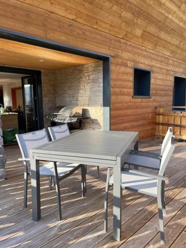 une table et des chaises sur une terrasse avec une cheminée dans l'établissement Superbe Chalet refait à neuf, idéal famille, Sportifs 2 nuits minimum, à Xonrupt-Longemer