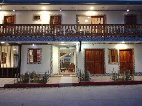 a white house with a balcony on top of it at Hotel Diamante in Saravena