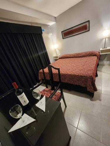 Schlafzimmer mit einem Bett und einem Tisch mit Weingläsern in der Unterkunft Los Cedros 43 in Salta