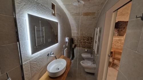 a bathroom with two toilets and a sink at Epoca B&B in Bitetto