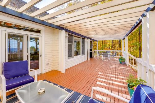 a screened porch with a blue chair and a table at Cottage with Private Beach and Fire Pit in Manistee! in Manistee