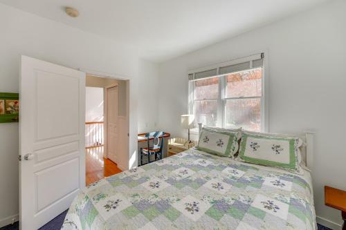 a white bedroom with a bed and a window at Cottage with Private Beach and Fire Pit in Manistee! in Manistee