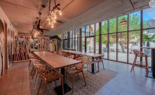 une salle à manger avec une table, des chaises et des fenêtres dans l'établissement Appartement 2 pièces entre centre ville et machine de l'île, à Nantes