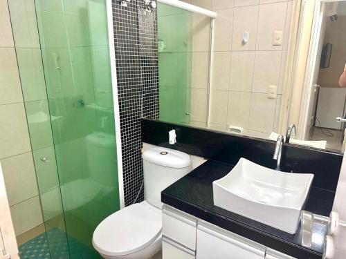 a bathroom with a toilet and a sink and a shower at Condomínio Natture Clube in Natal