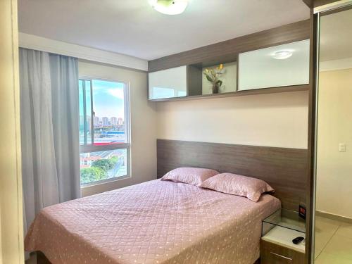 a bedroom with a bed and a large window at Condomínio Natture Clube in Natal