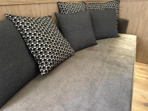 a couch with four pillows on it at Agritur Leita in Tuenno