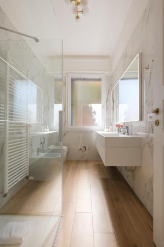 a white bathroom with two sinks and a shower at Sant'Orsola Lodge Bologna in Bologna