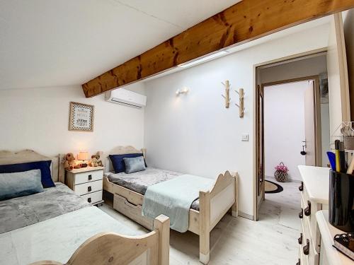 - une chambre avec 2 lits et une croix sur le mur dans l'établissement Coquet logement tout confort avec piscine, à Béziers