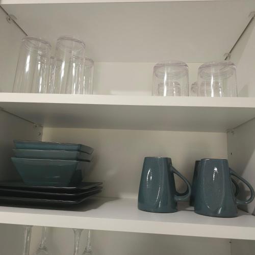 a shelf filled with glasses and plates and mugs at Simple Serenity in Freeport
