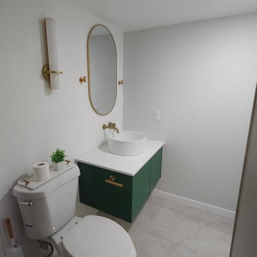 a bathroom with a toilet and a sink and a mirror at Simple Serenity in Freeport