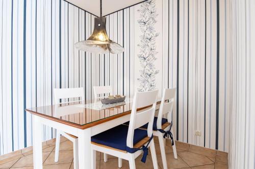 een eettafel met 2 stoelen en een lamp bij Wohnresidenz Wohnung 2 in Kellenhusen