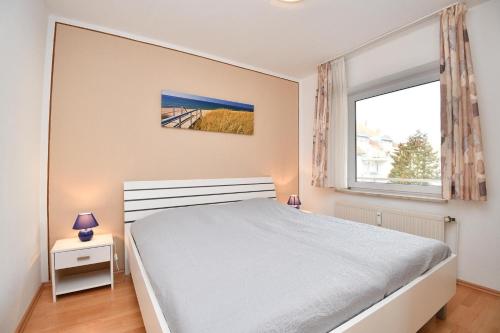 een slaapkamer met een wit bed en een raam bij Wohnresidenz Wohnung 2 in Kellenhusen