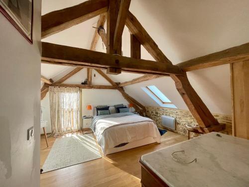 - une chambre avec un lit dans une pièce dotée de poutres dans l'établissement Domaine du ValféEric, à Saint-Sulpice-dʼExcideuil