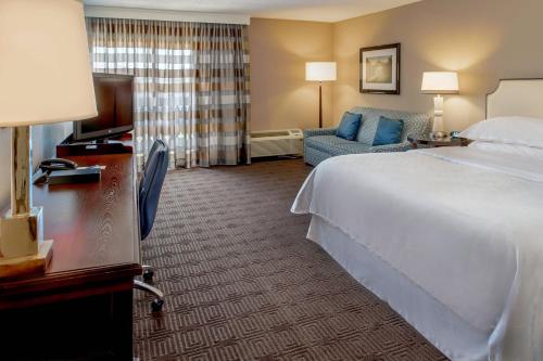 a hotel room with a bed and a couch at Sheraton Westport Lakeside Chalet in Maryland Heights