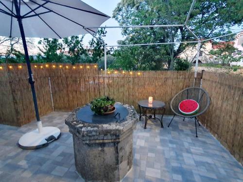 a patio with an umbrella and a table and chairs at Diana apartment in Gabonjin