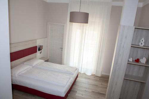 a bedroom with a bed and a large window at Hotel Benacus Torri del Benaco in Torri del Benaco
