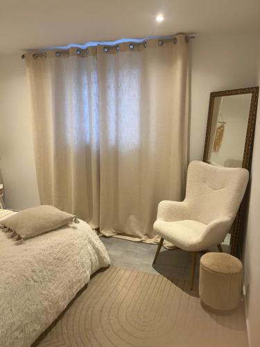 une chambre avec un lit, une chaise et un miroir dans l'établissement Evasion bohème, à La Celle-sous-Gouzon