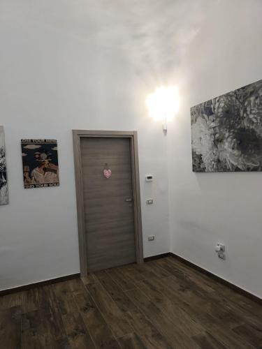 a room with a door and some pictures on the wall at Appia Apartment - Camera Fiorellino in Santa Maria a Vico