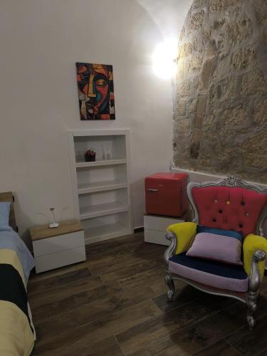 a bedroom with a bed and a chair and a wall at Appia Apartment - Camera Fiorellino in Santa Maria a Vico