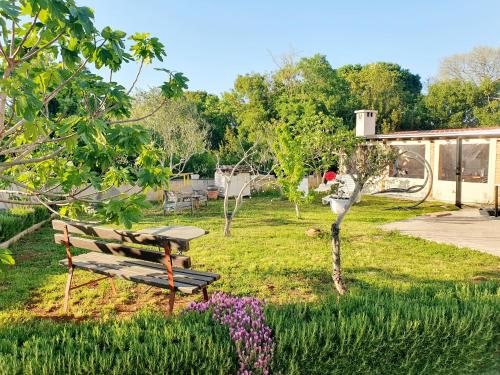 a park bench sitting in the grass with flowers at Diana apartment in Gabonjin