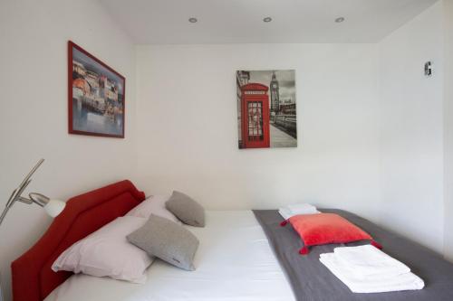 a bed in a room with a red phone booth at Apartments MaXhit in Tivat