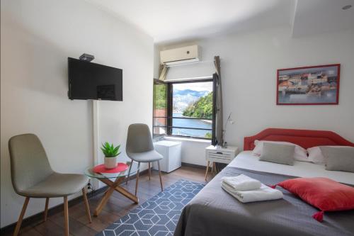 a bedroom with a bed and a tv and a window at Apartments MaXhit in Tivat
