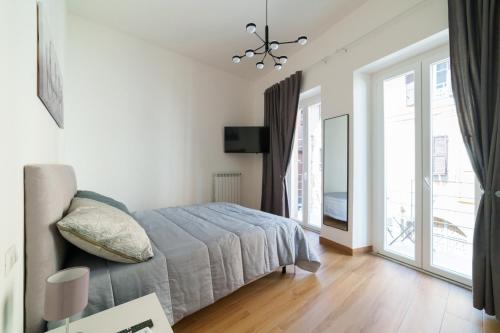 a bedroom with a bed and a large window at Residenze Saffi in Viterbo