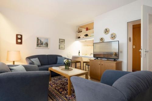 a living room with blue couches and a tv at Berolina Ostseegold in Dahme