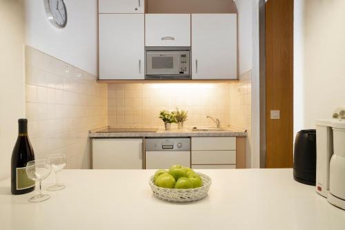 a kitchen with a bowl of apples and a bottle of wine at Berolina Ostseegold in Dahme
