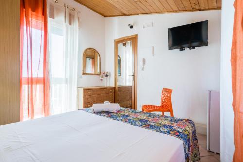 a bedroom with a bed and a tv on the wall at Villa Giummarito in Scicli