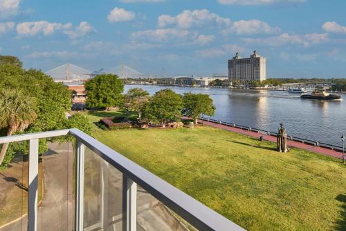 a person standing on a balcony overlooking a river at AC Hotel Savannah Historic District in Savannah