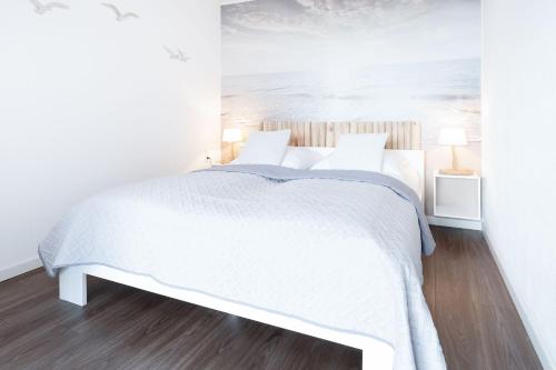 a white bedroom with a bed with white sheets at Berolina Badebude 214 in Dahme