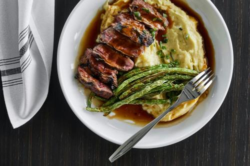 a plate of food with a steak and asparagus at AC Hotel Savannah Historic District in Savannah