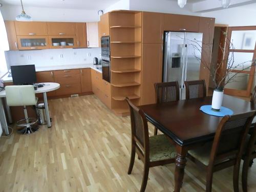 a kitchen with a table and chairs and a refrigerator at Pension Rondel in Poděbrady