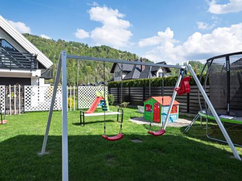 a childrens playground with swings and a swing set at Słoneczne Domki in Krościenko