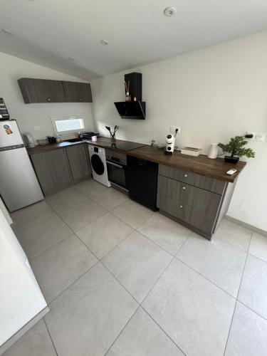 une cuisine avec une cuisinière et un réfrigérateur dans l'établissement Maison évasion détente, à Crémieu