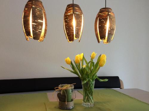 a table with a vase of yellow flowers and lights at BnB Haag in Haag