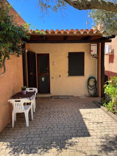 a patio with two white chairs and a table at La Trentasei in Rena Majore