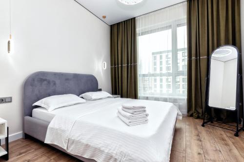 TaldykolʼにあるRaisson Ahotel Headliner E39-Khan Shatyrの大きなベッドと大きな窓のある寝室