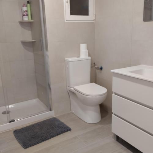 a bathroom with a toilet and a shower and a sink at Burrianna Beach Apartment in Burriana